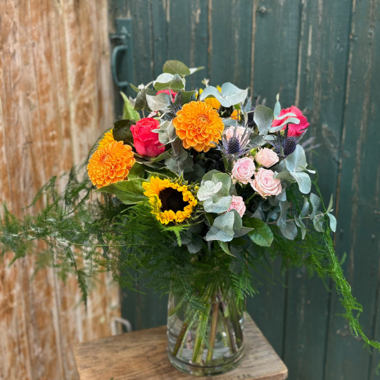 Colourful bouqyet in vase with dahlias, sunflowers and roses 